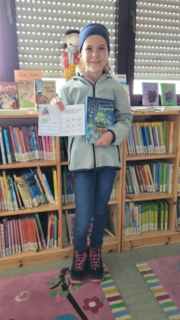 Gewinnerin - Mädchen hält Bücher in die Kamera