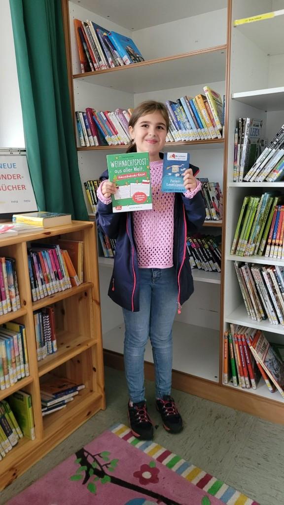 Gewinnerin - Mädchen hält Bücher in die Kamera